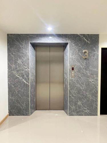 a elevator lobby with a stainless steel door at Re Riva in Ban Bang Bamru