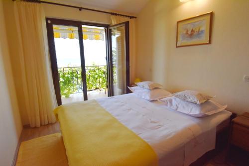 a bedroom with a large bed with a large window at Villa DELFINA in Podgora