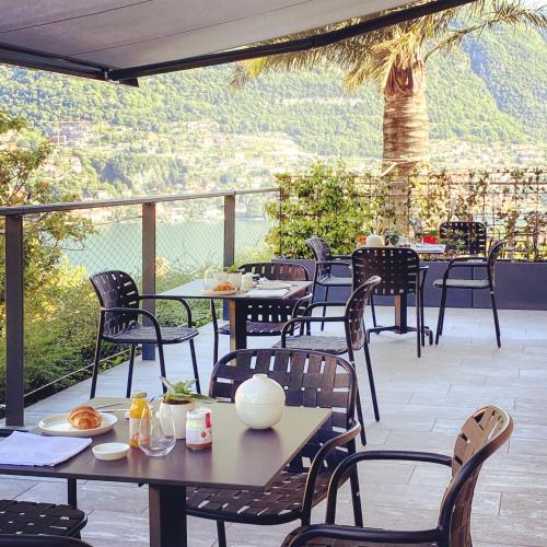 a patio with tables and chairs with a view at Hotel Lago in Torno