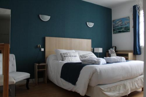 - une chambre avec un grand lit et un mur bleu dans l'établissement Hotel de L'Europe, La Roche-Posay, à La Roche-Posay