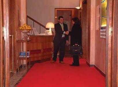 dos personas de pie en un pasillo con una alfombra roja en Hotel Moderno, en Rímini