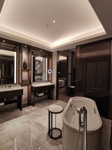 a large bathroom with a tub and a sink and a tub at Wanda Vista Changchun in Changchun