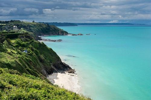 a view of the ocean from a hill with a beach at Maison à 30m de la plage avec grand jardin in Plérin