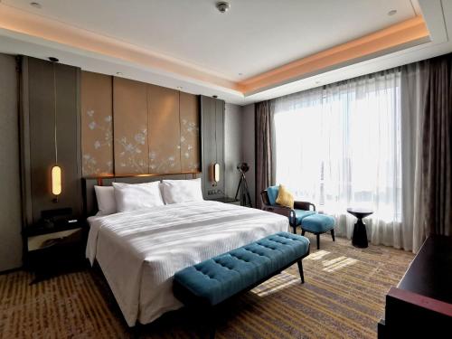 a hotel room with a bed and a large window at Wanda Vista Changchun in Changchun
