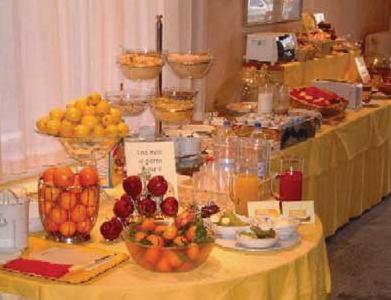 Hotel Moderno في ريميني: طاولة عليها الفواكه وغيرها من المواد الغذائية