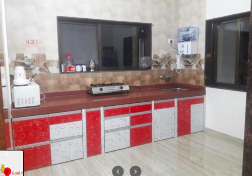 uma cozinha com um balcão vermelho e branco em Gold Nest Valley View 3BHK (3DAYS MINI. STAY) em Panchgani