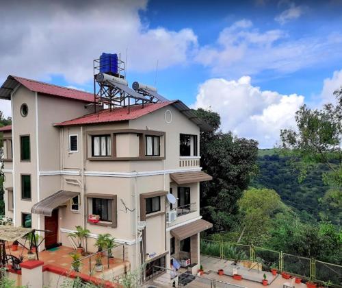 a building with a tower on top of it at Gold Nest Valley View 3BHK (3DAYS MINI. STAY) in Panchgani