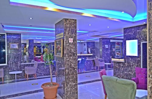 a room with purple and purple chairs and a bar at GARDEN ASMİN OTEl&SPA in Kızılbağ