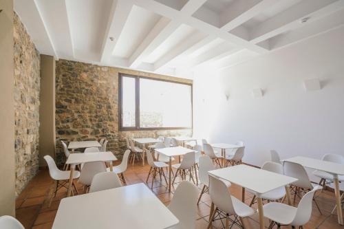 Pokój ze stołami i krzesłami oraz ceglaną ścianą w obiekcie La Albacara w mieście Moya