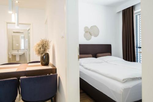 um quarto com uma cama e uma mesa com cadeiras em Apartman Balaton em Keszthely
