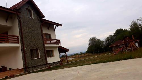 a building that is next to a road at Pensiunea Colț de rai in Polovragi