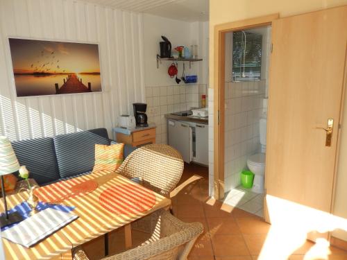 Bungalow (hälfte) Backbord Ahlbeck (Usedom) في آلبيك: غرفة معيشة مع طاولة وكراسي ومطبخ