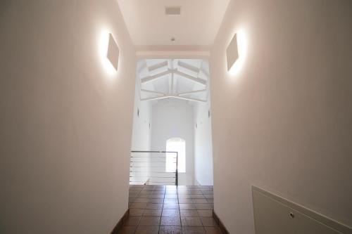 a hallway with white walls and a tile floor at La Albacara in Moya