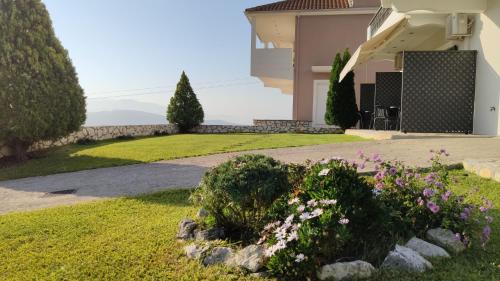 a garden in front of a house with flowers at Villa Gianna in Apolpaina