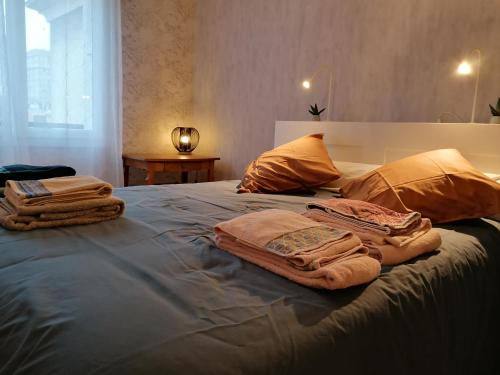 łóżko z ręcznikami na górze w obiekcie Le charme de l ancien entre mer et ville w Hawrze