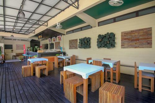 um restaurante com mesas e cadeiras de madeira numa sala em Rajata Hotel em Bangkok