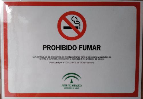 un cartello per un divieto di fumo su un muro di PENSIÓN LARRA a Mairena del Alcor