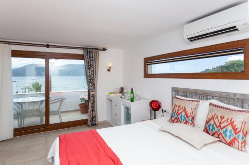 um quarto com uma cama e vista para o oceano em Mosso Boutique Hotel em Ula