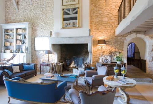 a living room with a fireplace and blue furniture at La Bastide de Marie, Maisons et Hôtels Sibuet in Ménerbes