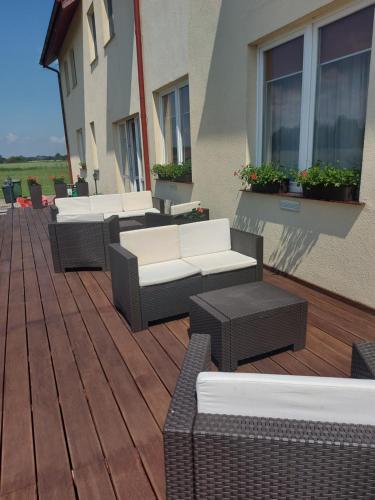a group of chairs and tables on a deck at Przystanek Czapla in Czaplinek