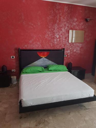 ein Schlafzimmer mit einem Bett mit einer roten Wand in der Unterkunft La tenuta di panfilo in Paglieta