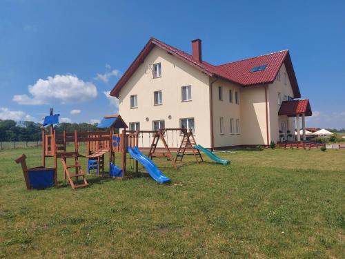 a house with a playground in front of a building at Przystanek Czapla in Czaplinek