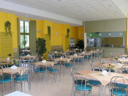 a dining room with tables and chairs and yellow walls at Nawojka Hotele Studenckie in Kraków