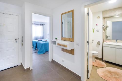 La salle de bains est pourvue de toilettes, d'un lavabo et d'un miroir. dans l'établissement AlbufeiraMar Apartment, à Albufeira