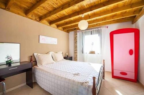 a bedroom with a large bed with a red door at Elisabeth Luxury Villas in Vourvourou