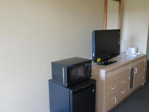 a television sitting on top of a dresser with a microwave at Howard Johnson by Wyndham Torrance in Torrance
