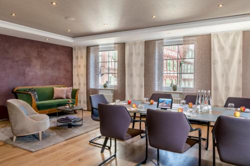 a room with a table and chairs and a couch at Hotel Krone in Bretten