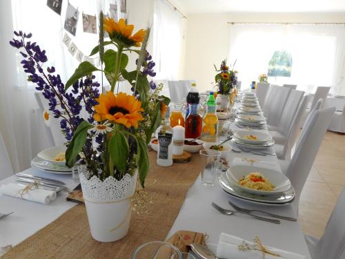 a long table with plates of food and flowers on it at Przystanek Czapla in Czaplinek