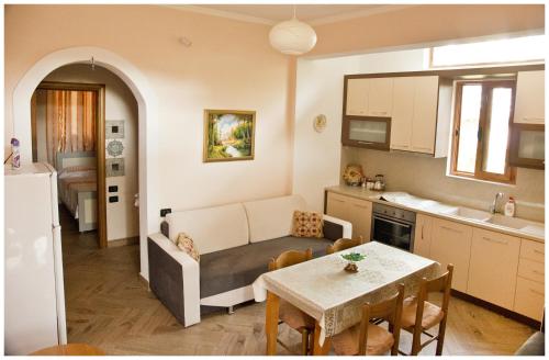 Il dispose d'une cuisine et d'un salon avec un canapé et une table. dans l'établissement Apartment Demaj, à Vlorë