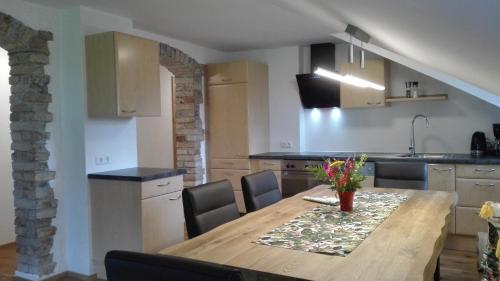 a kitchen and dining room with a wooden table and chairs at Gästehaus Hosp in Reutte
