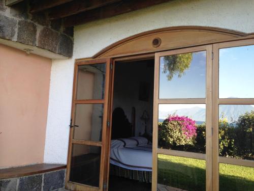 an open door to a bedroom with a bed outside at Hotel Posada de Don Rodrigo Panajachel in Panajachel