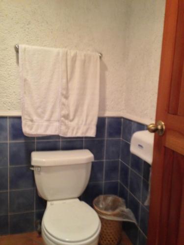 a bathroom with a white toilet and blue tiles at Hotel Posada de Don Rodrigo Panajachel in Panajachel