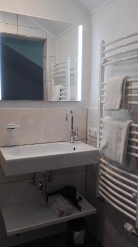 a bathroom with a sink and a mirror and towels at Gästehaus Hosp in Reutte