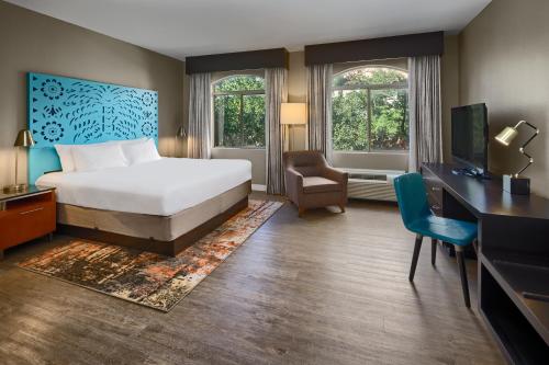 a hotel room with a bed and a desk and a tv at Hotel Indigo San Antonio Riverwalk by IHG in San Antonio
