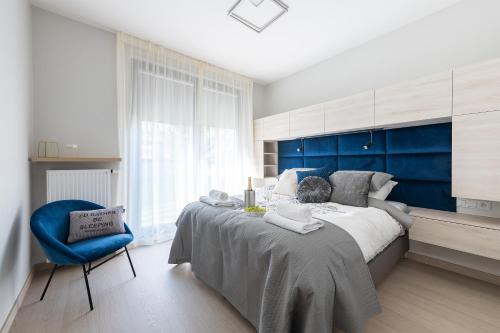 1 dormitorio con 1 cama grande y pared azul en Business Kasprzaka Serviced Apartments P&O, en Varsovia