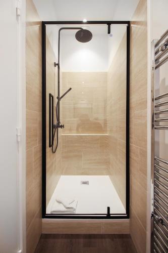 une douche avec une porte vitrée dans une salle de bain dans l'établissement Modern Apt 3BDR/3BATH - Louvre Museum/Tuileries, à Paris