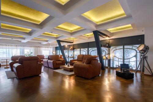 a living room with couches and chairs in a building at Casa Hrisicos in Constanţa