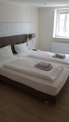 a large white bed with two towels on it at Landhotel Klempau in Lübeck