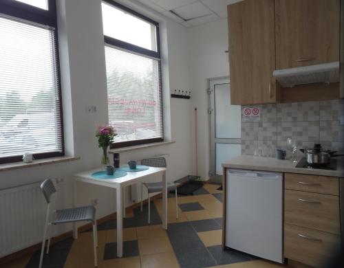a kitchen with a table and chairs in a room at Nowy Apartament Słoneczny in Augustów