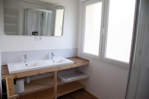 baño con lavabo, espejo y ventana en La Châtelaine en La Rixouse