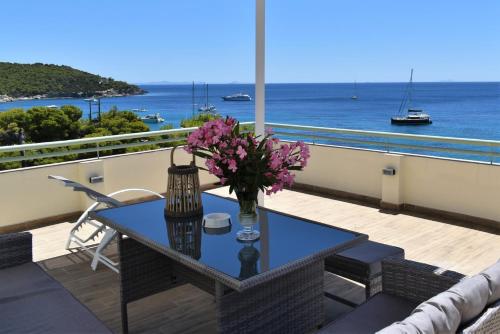 a table on a balcony with a view of the ocean at Panorama Hotel in Agia Marina Aegina