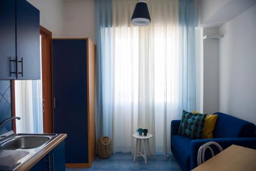 a living room with a blue couch and a window at Residence Panoramic in Maiori