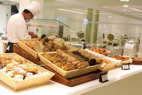 a chef in a bakery with many different types of pastries at Pine Cliffs Village in Albufeira