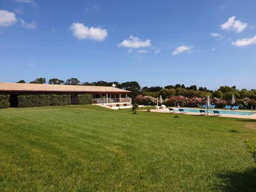 un gran patio con un edificio y una piscina en Agliadò, en Platamona