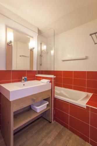 une salle de bain avec un lavabo, une baignoire et un miroir dans l'établissement Résidence Les Gémeaux - Belle Plagne, à La Plagne