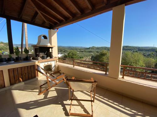 a balcony with two chairs and a stove at Theologos Traditional House in Theologos